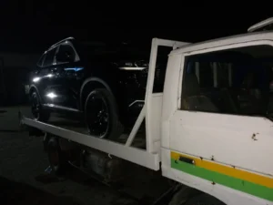 Black Car on tow truck at night in Islamabad